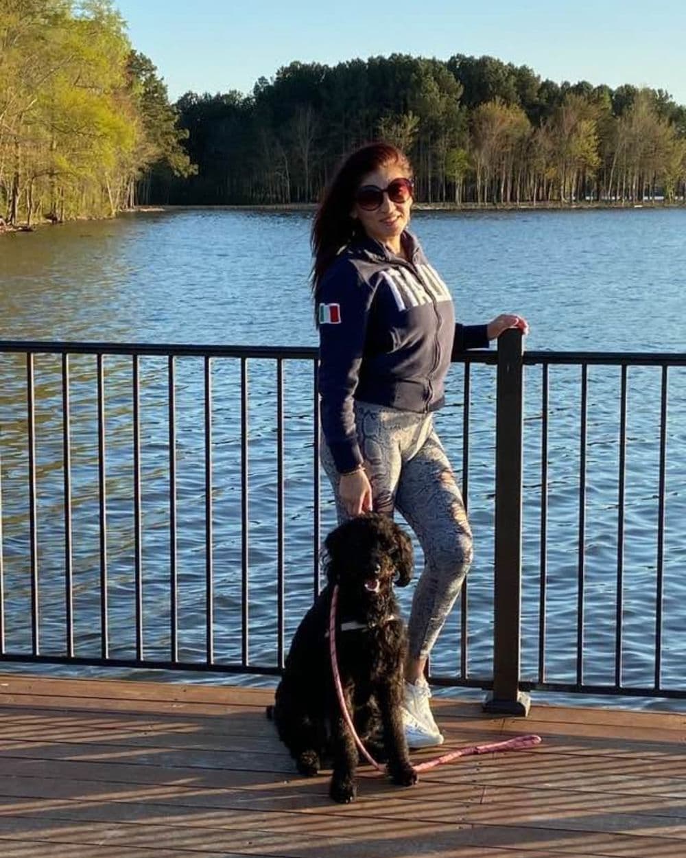 Angelica Rios outdoors with her dog on a lakeside dock
